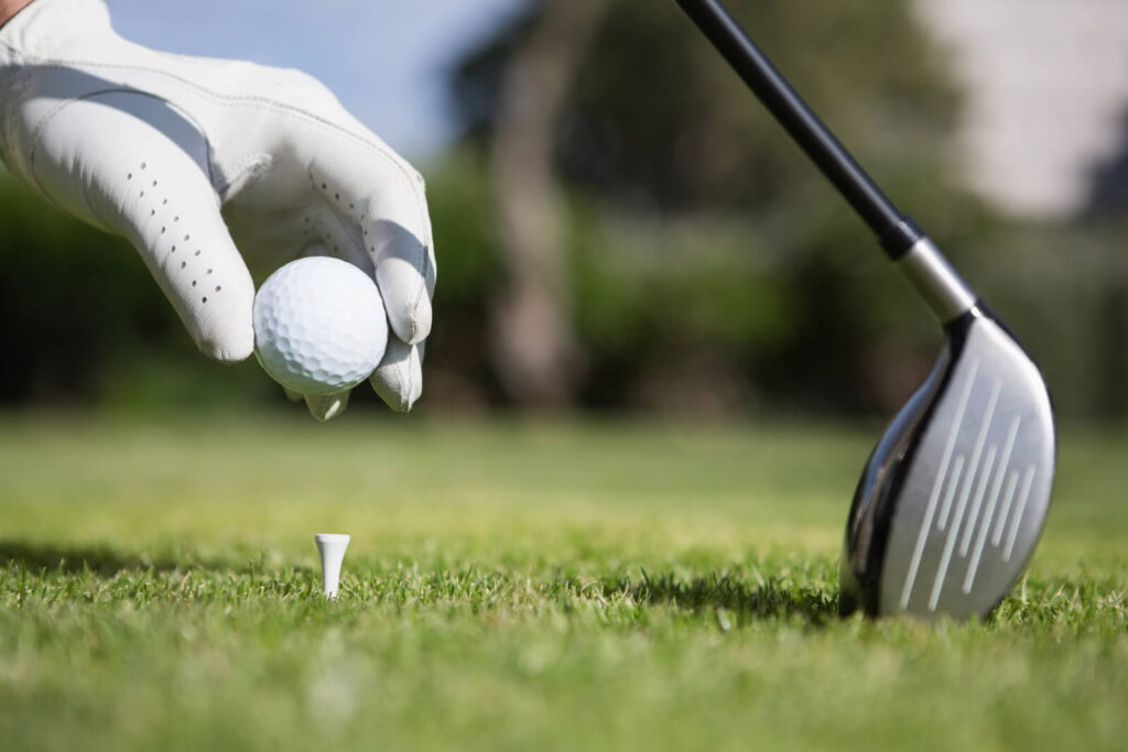 golfer puts ball on tee